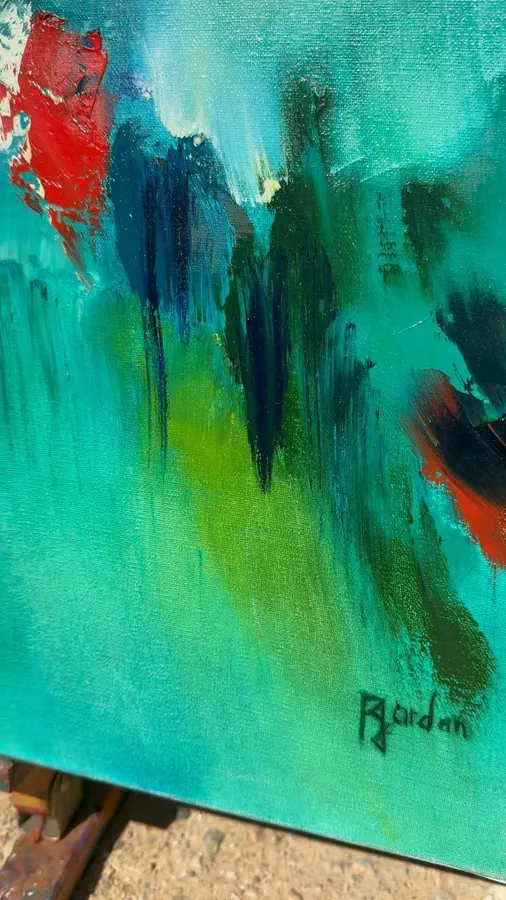 Gros plan d'un tableau abstrait vert et turquoise de Régine Gardan, touches rouges et bleu nuit, signé Gardan